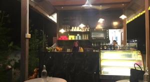a woman sitting at a bar in a restaurant at Kampong Pinang Sebatang Melaka in Pengkalan Balak