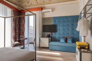 a hotel room with a bed and a couch at Belduomo Catania Rooms & Flat in Catania