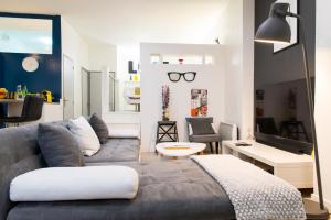 a living room with a couch and a living room with a tv at Unsejouranantes- Loft Cassard in Nantes