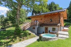 a log house with a swimming pool in front of it at Chalet Die Mühle in Saalfelden am Steinernen Meer