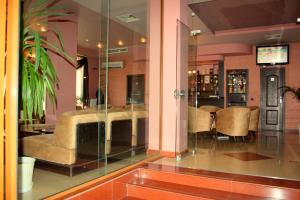 a lobby with a couch and a table and chairs at Hotel Elegant in Karnobat