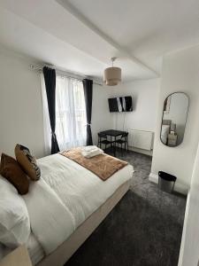 Un dormitorio con una cama, una mesa y un espejo. en The Luma Suite, en Albrighton