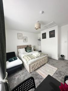 a bedroom with a bed and a couch at The Luma Suite in Albrighton