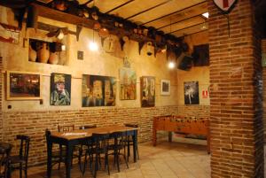 a room with a table, chairs, and a clock on the wall at Fonda Del Tozal in Teruel