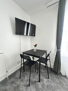 a black table with chairs and a vase of flowers on it at The Luma Suite in Albrighton