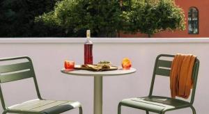 a table and two chairs with a bottle of wine at HS Hotel Siswa Near UTAR in Kampar