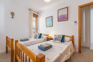 two twin beds in a room with a window at Casa El Valle Verde Granada in Lecrin