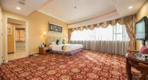 una habitación de hotel con una cama y una ventana grande en Shunde Emperor Hotel, en Shunde