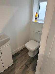 une salle de bain avec toilettes, lavabo et fenêtre dans l'établissement Modern 3 Bed with 3 Baths and Parking, Near Centre, à Bredbury 1 autre photo