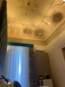 a room with a ceiling with a window and a chandelier at Belduomo Catania Rooms & Flat in Catania