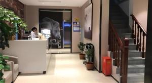 Una mujer parada en un mostrador de una tienda en Jtour Inn Suizhou Yanhe Avenue, en Suizhou