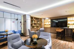 ein Wohnzimmer mit Tisch und Stühlen in der Unterkunft Echarm Hotel Shenyang Nanta Shoe City Army General Hospital in Shenyang