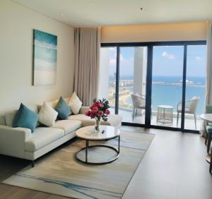 un salon avec un canapé et une table dans l'établissement HB Serviced Apartment - Alacarte Hạ Long, à Hạ Long