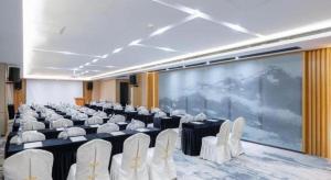 einen Konferenzraum mit Stühlen und einem großen Bildschirm in der Unterkunft Longuu Hotel Zhaoqing in Zhaoqing
