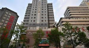 zwei hohe Gebäude in einer Stadt mit Bäumen in der Unterkunft City Comfort Inn Kunming Railway Station Guanshang in Kunming