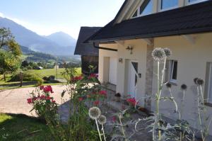 ein weißes Haus mit Blumen davor in der Unterkunft Apartment Stepanjan in Bled