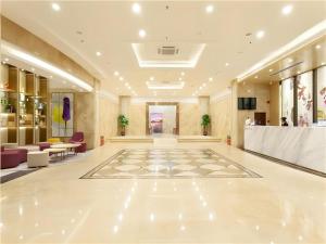 eine Lobby mit großem weißen Boden und Tischen und Stühlen in der Unterkunft Lavande Hotel Guangzhou Zengchen Xintang Light Railway Station in Zhongtang
