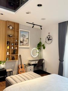 a bedroom with a bed and a desk and a guitar at Modern Studio Apartment in Hanoi