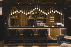 un bar con sillas negras y candelabros en Luminoso Boutique Hotel, en Budva