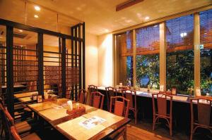 TakaraにあるHotel Gran View Okinawaの木製のテーブルと椅子と窓のあるレストラン