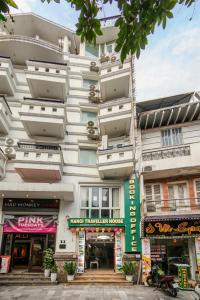 a tall white building with shops in front of it at Hanoi Traveller House in Hanoi