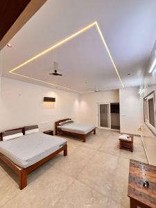 a large room with two beds and a table at Rajkamal Hampi in Hospet