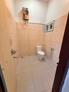 a bathroom with a toilet and a shower at Rajkamal Hampi in Hospet +2 photos