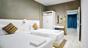 Una habitación de hotel con dos camas y un espejo. en Paragon Hometel, en Suratthani 246 fotos más