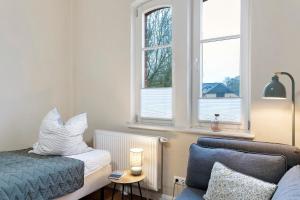 a bedroom with a bed and a chair and a window at Haevn Altes Pfarrhauss Marienfliess in Stepenitz