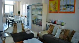 a room with two couches in a restaurant with tables at 7 Days Inn Yantai Dahaiyang Raod Railway Station in Yantai