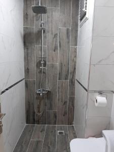 uma casa de banho com um chuveiro e uma parede de madeira em Samlife Apart em Samsun