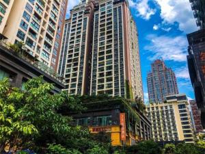 Fulingにある7 Days Premium Chongqing Fuling Binjiang Avenue Branchの植物が植えられた高い建物