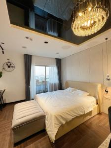 a bedroom with a large bed and a chandelier at Modern Studio Apartment in Hanoi