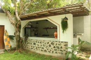 a house with a window in the side of it at The Drop In Surfhouse Madiha in Madihe East