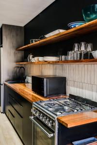 a kitchen with a stove and a microwave at Hidden Gem Llandudno Studio in Llandudno