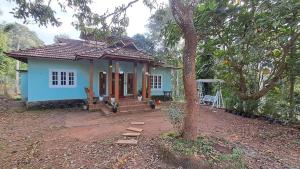a small blue house with a tree in front of it at Aura Eco Friendly Resort in Sultan Bathery +5 photos