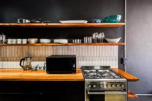 a kitchen with a stove and a microwave at Hidden Gem Llandudno Studio in Llandudno +2 photos