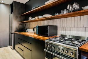 a kitchen with a stove and a microwave at Hidden Gem Llandudno Studio in Llandudno