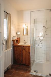 a bathroom with a shower and a tub and a sink at Das KRANACH 28 in Fötschach