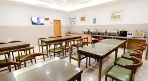 ein Esszimmer mit Tischen und Stühlen und eine Cafeteria in der Unterkunft GreenTree Inn Suzhou North Zhongshan Road Weiye Yingchun Plaza Business Hotel in Suzhou