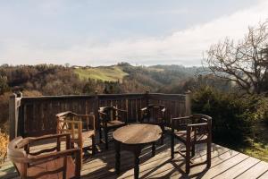 a table and chairs on a deck with a view at Das KRANACH 28 Weinberg Hideaways mit Whirlpool und Sauna in Fötschach