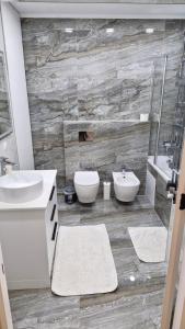 Un baño con lavabo, inodoro y espejo. en Odyssey, en Chişinău 55 fotos más