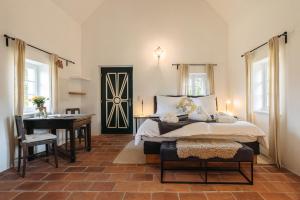 a bedroom with a bed and a table and a piano at Das KRANACH 28 Weinberg Hideaways mit Whirlpool und Sauna in Fötschach