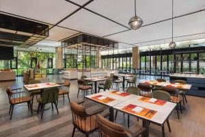 a dining room with tables and chairs in a restaurant at Four Points by Sheraton Haikou International Airport in Haikou
