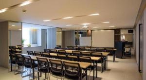 a conference room with tables and chairs and a screen at Jinjiang Inn Select Foshan Nanhai Guicheng Metro Station in Nanhai
