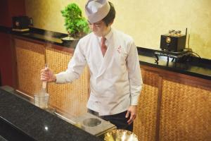 a chef standing in a kitchen preparing food at ご当地ラーメン食べ放題 "The RAMEN HOTEL" -京都嵐山- in Kyoto