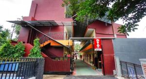 a red building with a red fence next to a street at OYO 1720 A2b Residence in Malalayang