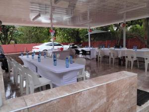 a group of tables and chairs with a car in the background at Best Enough Guesthouse in Pretoria