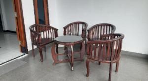 three wooden chairs and a table and a table and four chairs at Hotel O Panderman Residence in Karangtengah