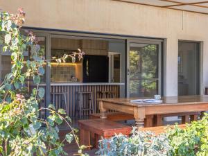 a screened in porch with a table and benches at Mariners Rest in Yamba